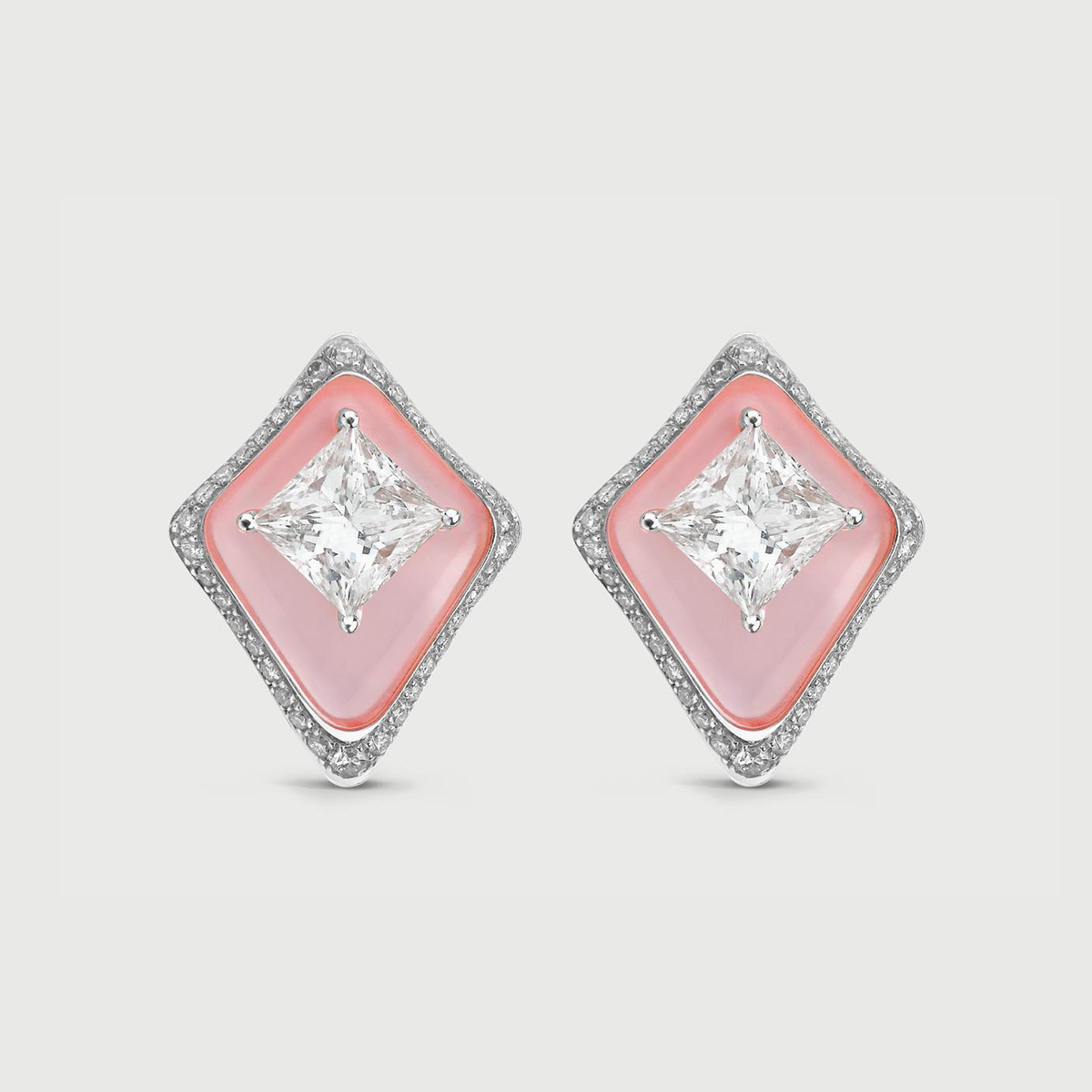 Diamond earrings with pink gemstones on a light gray background