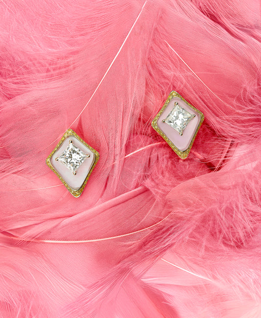 Pair of diamond earrings on pink feathers