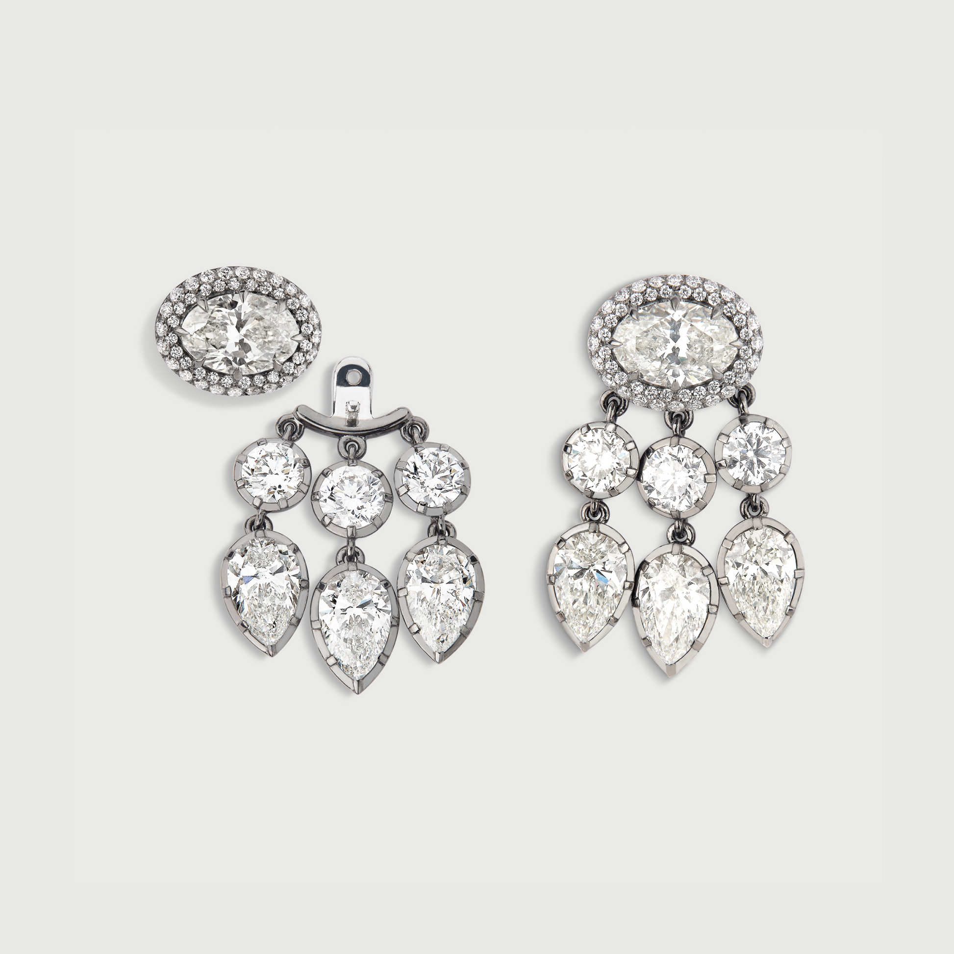 Pair of chandelier earrings with clear gemstones on a light gray background