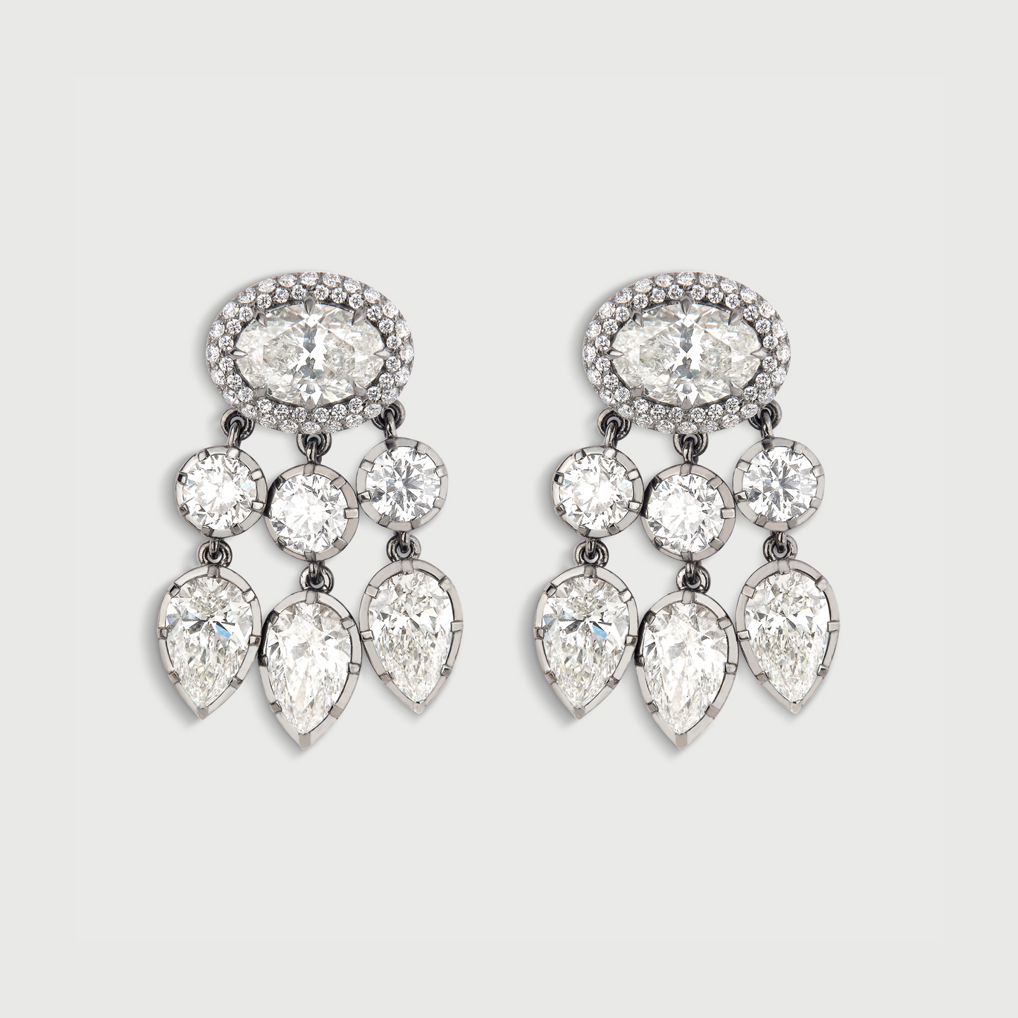Pair of chandelier earrings with clear gemstones on a light gray background