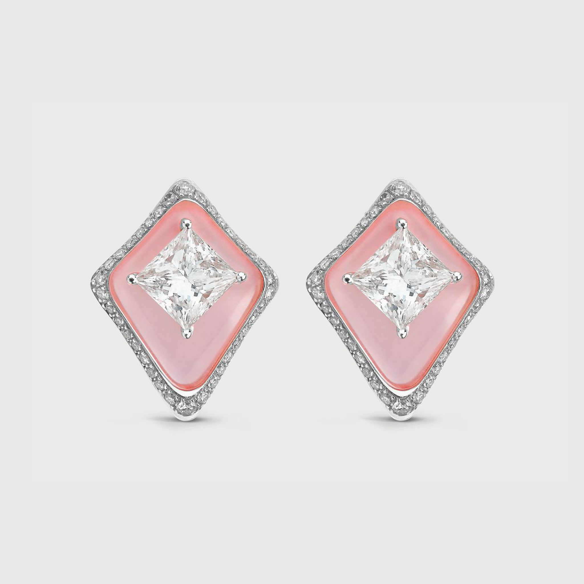 Diamond earrings with pink gemstones on a light gray background