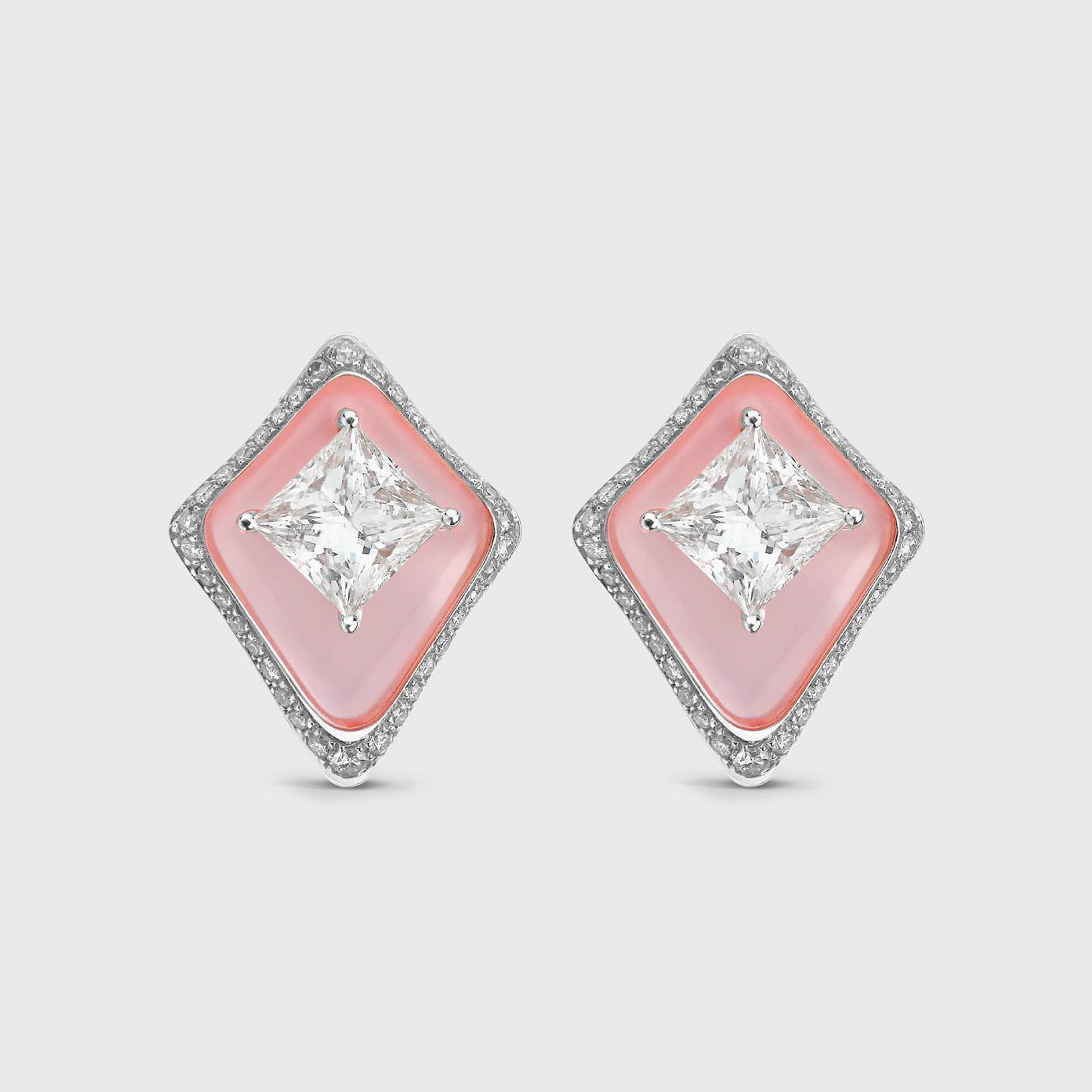 Diamond earrings with pink gemstones on a light gray background