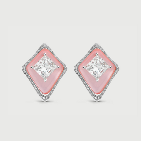 Diamond earrings with pink gemstones on a light gray background