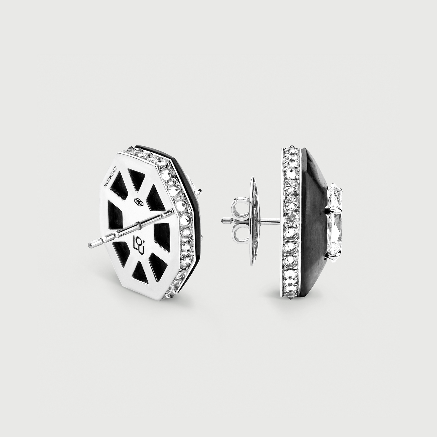 Hexagonal earrings with black and white design on a light gray background