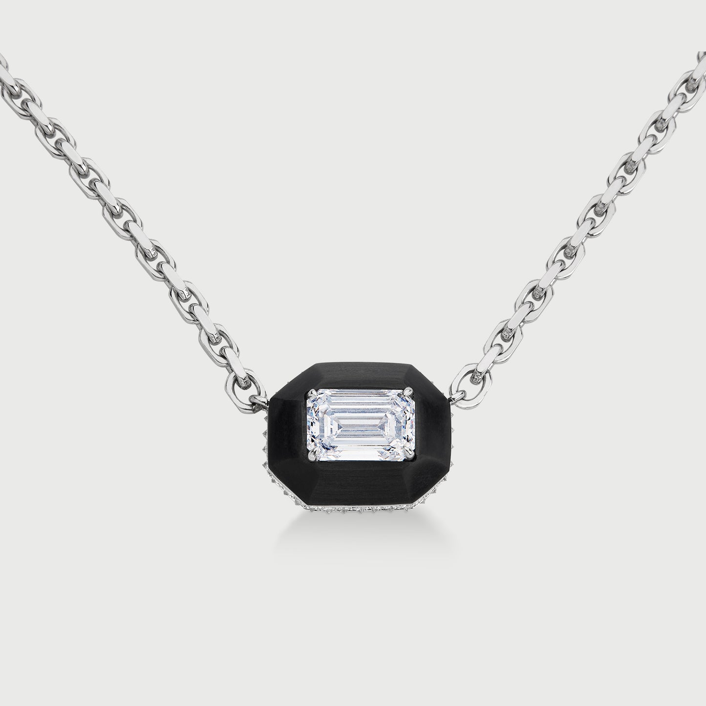 Necklace with a black pendant featuring a diamond on a light gray background