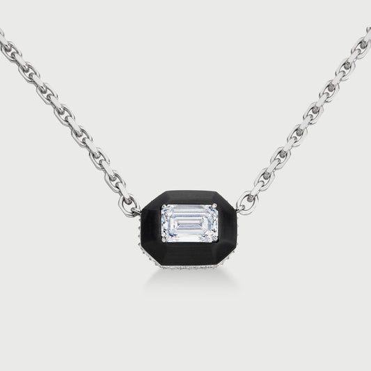 Necklace with a black pendant featuring a diamond on a light gray background