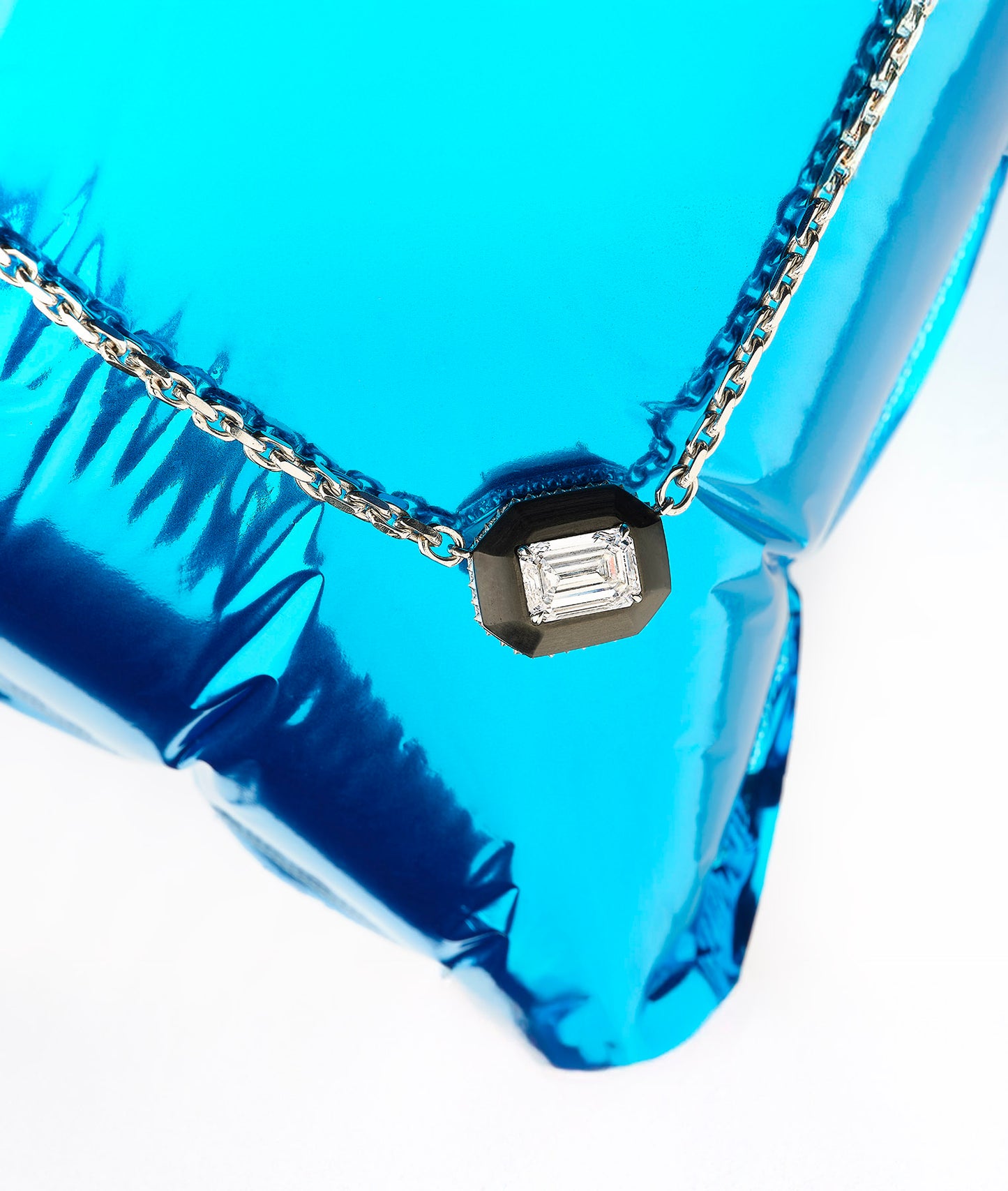 Diamond necklace on a blue metallic surface