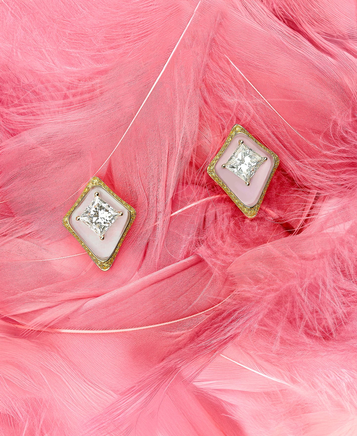 Pair of diamond earrings on pink feathers